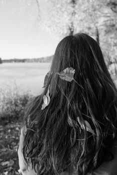 Young woman's hair with leafs waiting by road