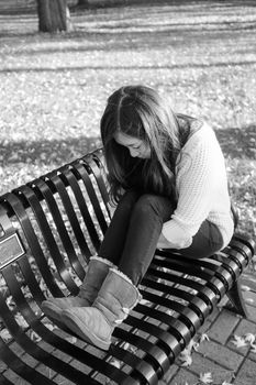 lonely young woman sitting on a steel bench