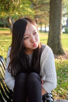 lonely young woman sitting on a steel bench