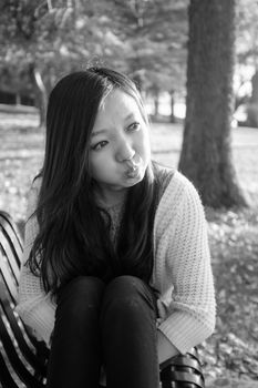 lonely young woman sitting on a steel bench