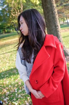 Young woman with coat half on looking sad