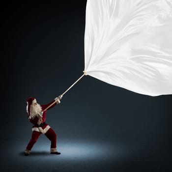 Santa Claus pulls a banner of cloth with a rope, place for text