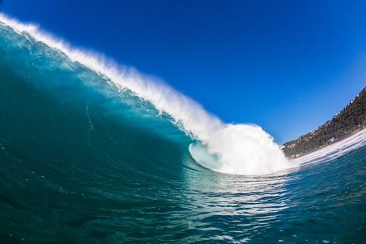 Water angle of large ocean hollow wave crashing breaking towards reefs and sandbars.