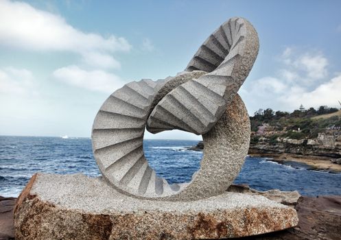 BONDI BEACH, AUSTRALIA - OCTOBER 30, 2013: Sculpture By The Sea, Bondi 2013. Annual event that showcases artists from around the world  Sculpture titled '2 rings' by Keizo Ushio, medium, granite $115000.  Image has been toned.
