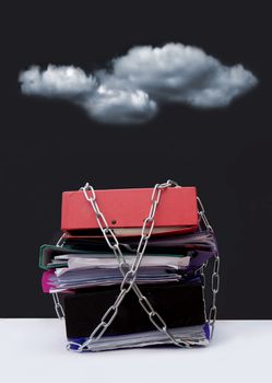 Dark clouds hovering over a pile of chained documents and files 