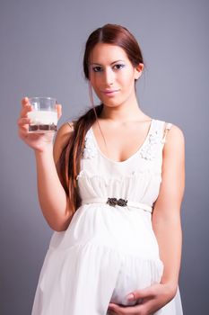 portrait of pregnant woman holding glass of milk
