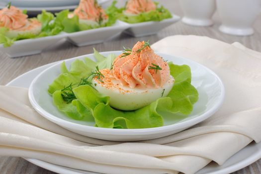 Eggs stuffed with pate salmon with red pepper in lettuce leaves
