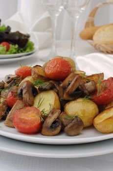 Fried potatoes with mushrooms and tomato