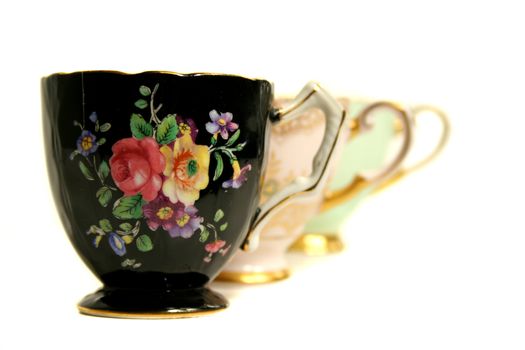 Three different colored antique teacups echoed in a line.