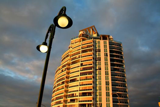 Modern apartment tower with streetlight in the early morning sun.