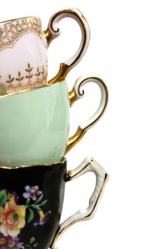 Three antique teacups stacked with gold plated handles. 