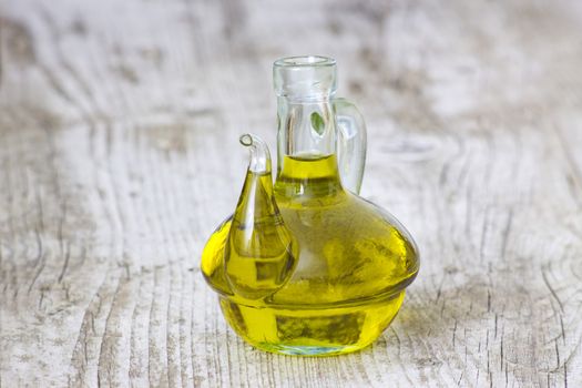 Olive oil in a bottle on wooden background