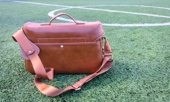 Vintage leather bag on green grass