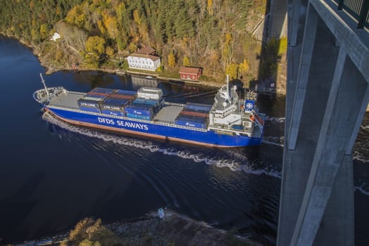 MV Lysbris sailing through Ringdalsfjord from Halden, Norway harbor and out to the open ocean. Vessel's Details: Ship Type: Cargo / container ship, built 1999, Length x Breadth: 129 m X 18 m, Gross Tonnage: 7409, DWT (deadweight tons): 7500 h, Flag: Norway (NO). Photo is shot from Svinesund bridge 18 October 2013.