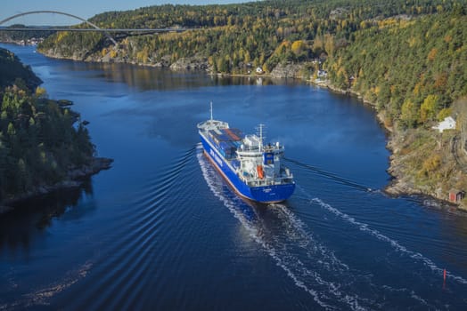 MV Lysbris sailing through Ringdalsfjord from Halden, Norway harbor and out to the open ocean. Vessel's Details: Ship Type: Cargo / container ship, built 1999, Length x Breadth: 129 m X 18 m, Gross Tonnage: 7409, DWT (deadweight tons): 7500 h, Flag: Norway (NO). Photo is shot from Svinesund bridge 18 October 2013.