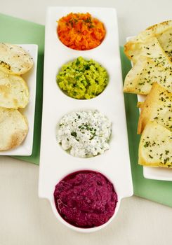 Assorted dips of beetroot, carrot, cottage cheese and herbs, pea and basil with pita crisps.