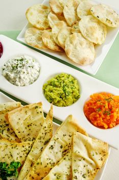 Assorted dips of carrot, cottage cheese and herbs, pea and basil with pita crisps.