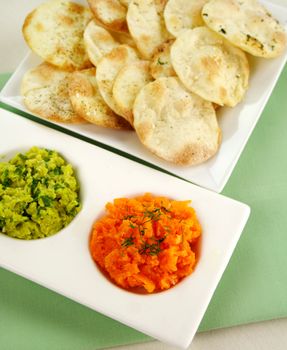 Assorted dips of carrot and herbs, pea and basil with pita crisps.