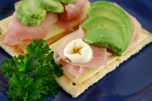 Ham, cheese and avocado crackers with hot english mayo.