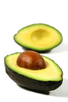 Avocado cut in half with seed in one half.