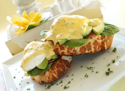 Beautiful eggs benedict with bacon and a rich hollandaise sauce on tiger crust bread.