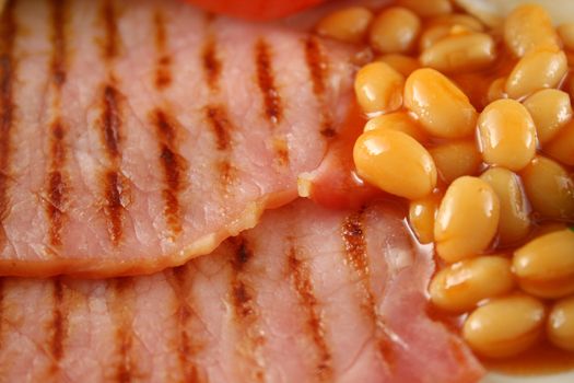 Breakfast of grilled bacon and baked beans.