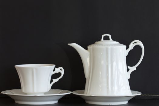 Tea cup and tea pot white on black background