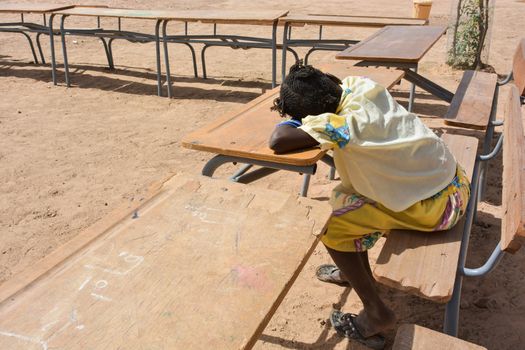 African child on the bench of school