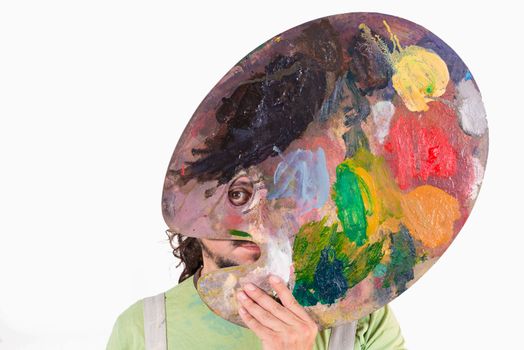 Portrait of an eccentric painter holding his palette in front of his face