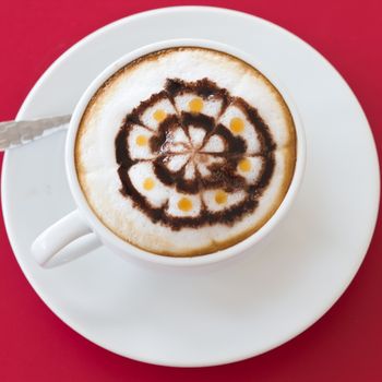 Coffee in a white cup on a red background.