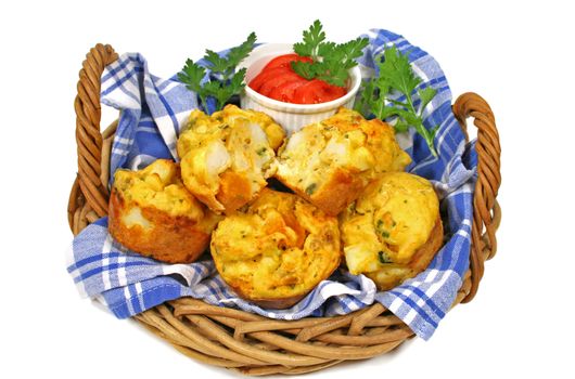 Basket of freshly baked vegetable muffins with garnish ready to serve.