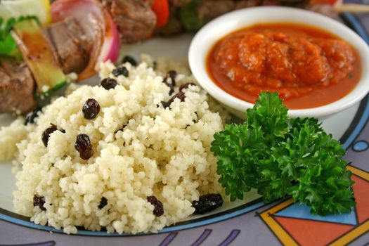 Beef kebabs and currant couscous with harissa sauce.