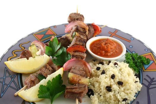 Beef kebabs and currant couscous with harissa sauce.