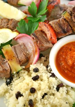 Beef kebabs and currant couscous with harissa sauce.