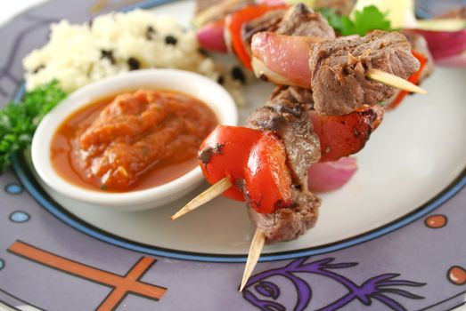 Beef kebabs and currant couscous with harissa sauce.