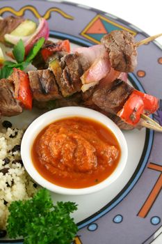 Beef kebabs and currant couscous with harissa sauce.