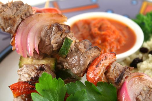 Beef kebabs and currant couscous with harissa sauce.