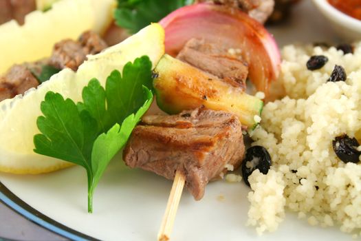 Beef kebabs and currant couscous with lemon ready to serve.