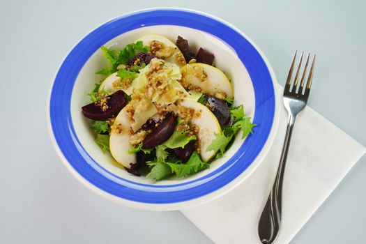 Delicious freshly made pear, beetroot and walnut salad ready to serve.