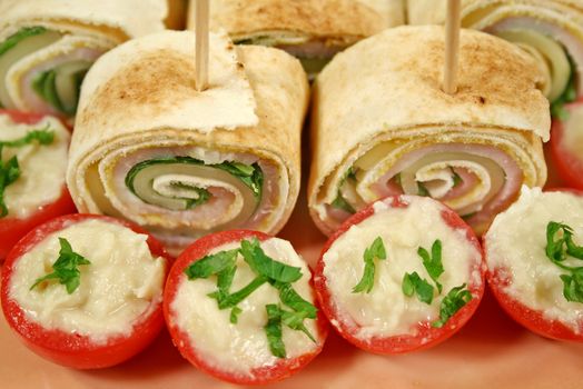 Bite size roll ups with ham, cheese and spinach and stuffed cherry tomatoes.