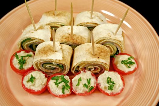 Bite size roll ups with ham, cheese and spinach and stuffed cherry tomatoes.