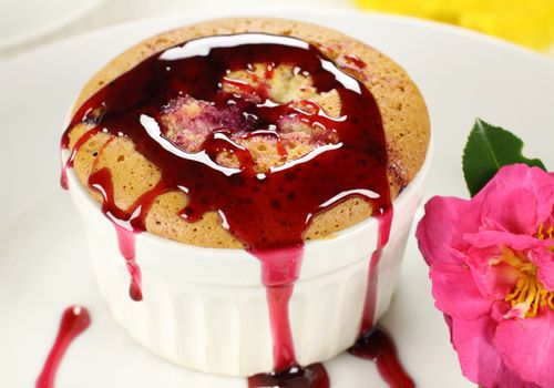 Delicious sponge pudding with blackberry sauce ready to serve.