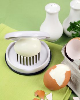 Egg slicer with boiled eggs and salt and pepper.