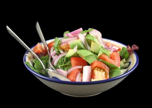 Delightful bowl of freshly prepared garden salad with spoon and fork.