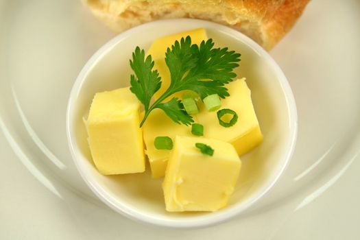 Chunks of butter with parsley and spring onion garnish.