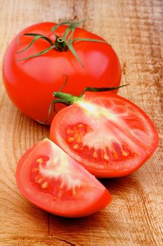 Fresh Ripe Tomatoes Full Body and Halves on Rustic Wooden background