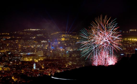 Night view of the city of Barcelona, with exploding fireworks