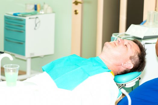 Middle aged men in dentist office ready for procedure