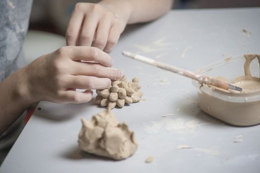 Girl make toyfrom clay. High resolution image.