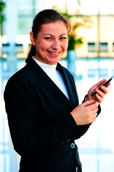 Young happy business woman with a mobile phone in hand